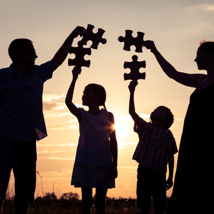 Happy family standing in the park at the sunset time. Happy family standing in the park at the sunset time. People having fun outdoors. Concept of friendly family.